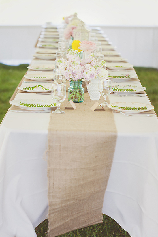Elegant wedding table setting with flowers and burlap runner