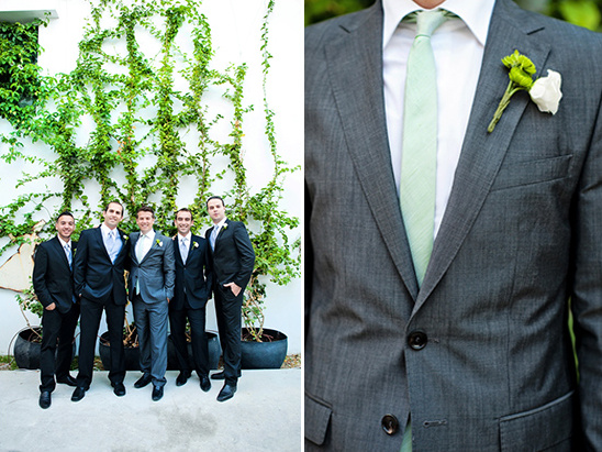 Groomsmen in gray suits pose by ivy wall