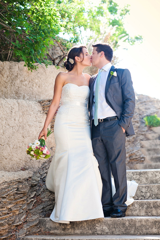 Bride and groom kissing on wedding day steps