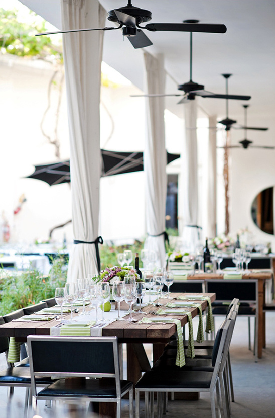 Outdoor wedding reception table setting with ceiling fans