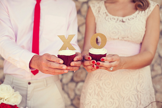 Couple holding XO cupcakes; romantic wedding treat