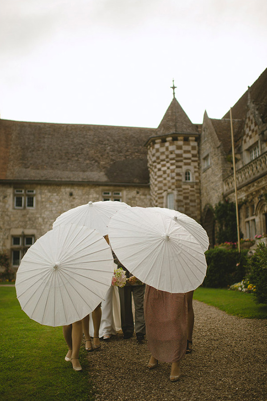 Bridesmaids with parasols at castle wedding