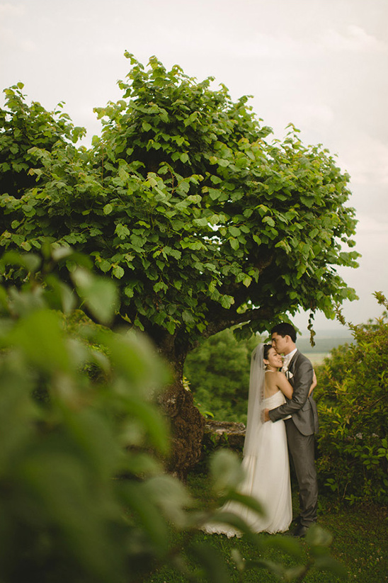Romantic wedding couple embracing under a tree