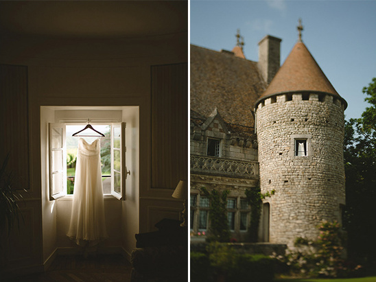 Wedding dress hangs in window; chateau in background