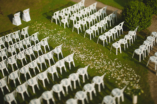 White chairs arranged for an outdoor wedding ceremony