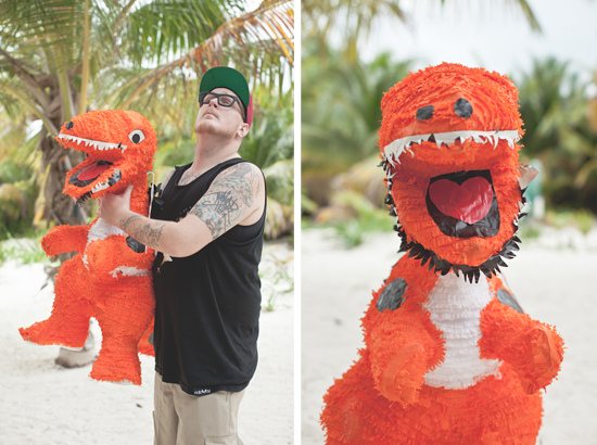 Man in black tank top holding dinosaur piñata