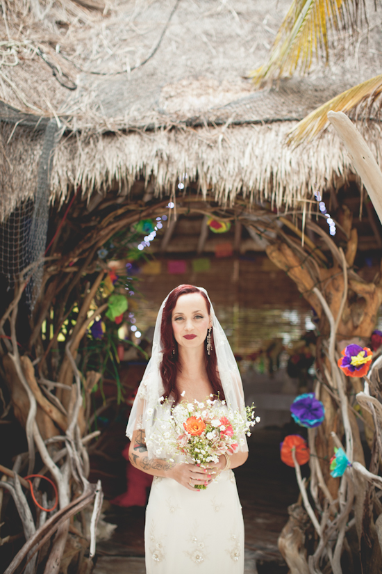 Bride at tropical wedding ceremony with flower bouquet
