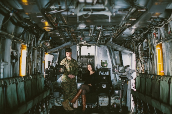 Marine and woman pose inside military transport aircraft