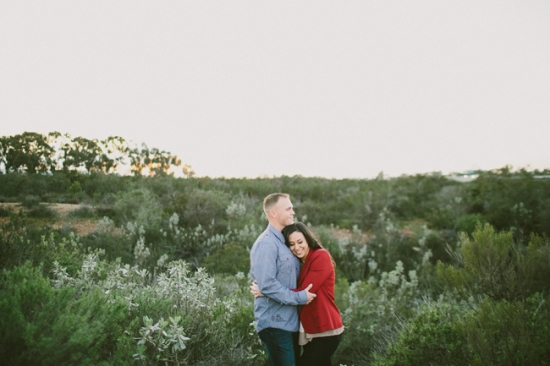 Loving couple embracing in a field at sunset