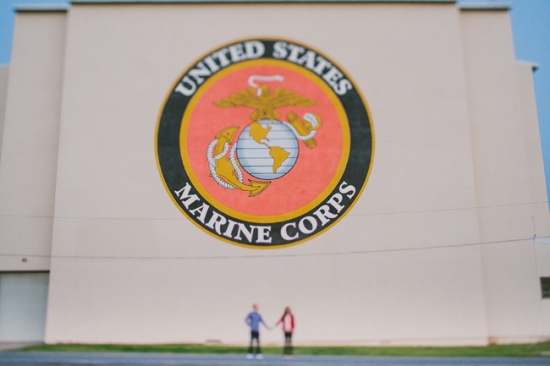 Couple in front of US Marine Corps emblem on building wall