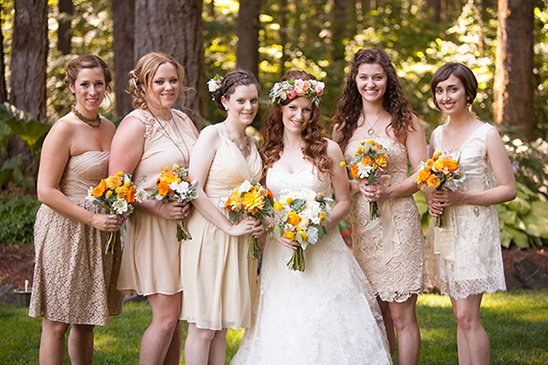 Bride and bridesmaids in beige dresses with orange bouquets