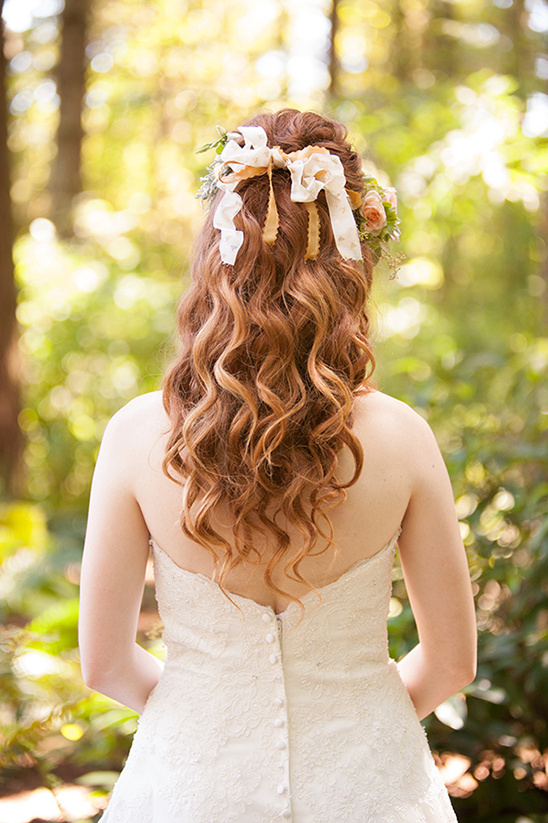 Bride with curly hair and floral ribbon wedding hairpiece