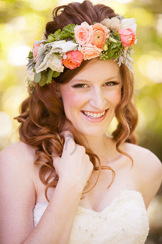 Bride smiling with floral crown and lace wedding dress