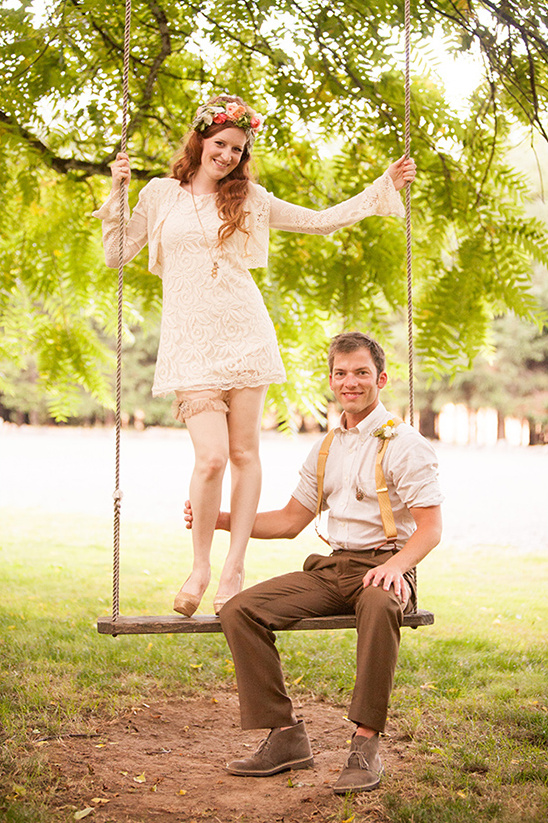Boho chic wedding couple posing on a swing set outdoors