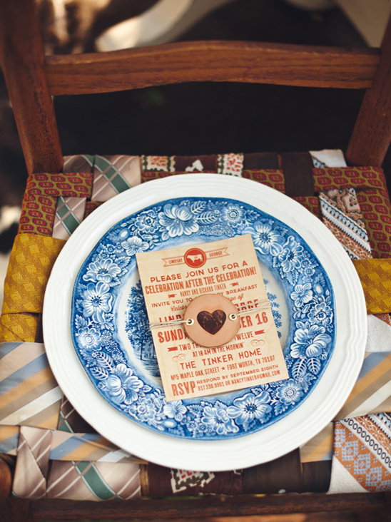Wedding invitation on a blue floral plate on chair