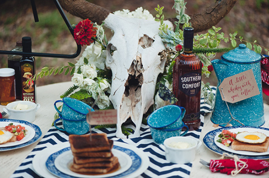 Rustic brunch table with skull flowers and Southern Comfort