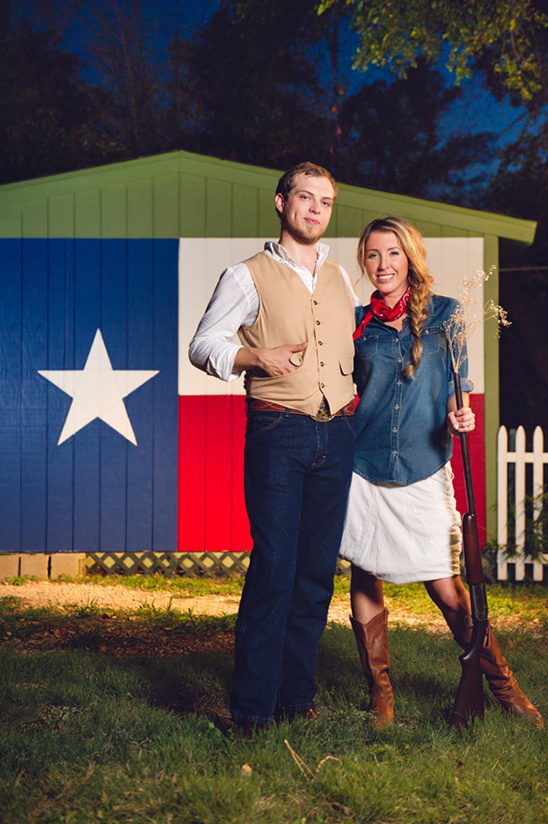 Texas couple with rifle in front of Texas flag house