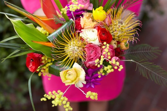 Colorful bouquet of flowers held by a woman in a pink dress