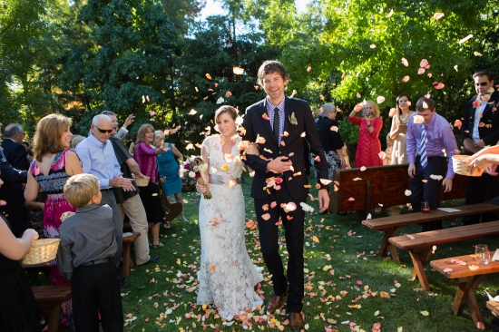 Wedding couple walks through flower petals