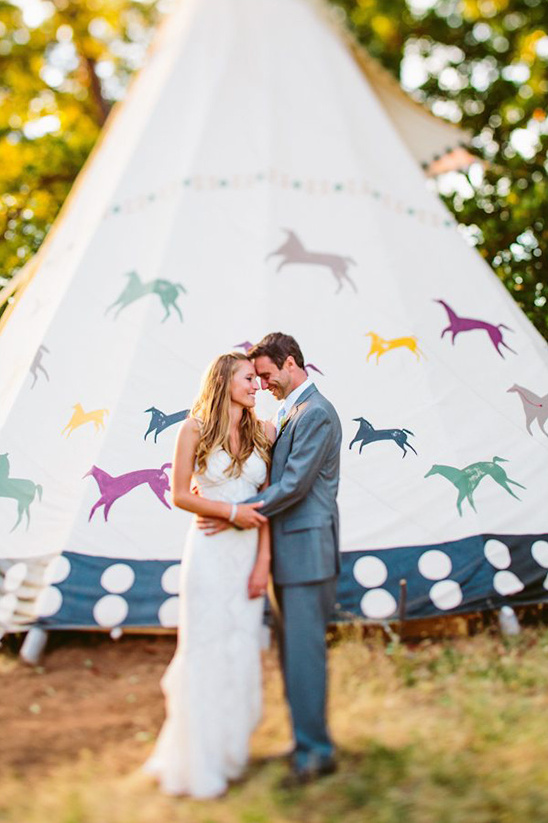 Happy couple embracing at wedding in front of decorated tent