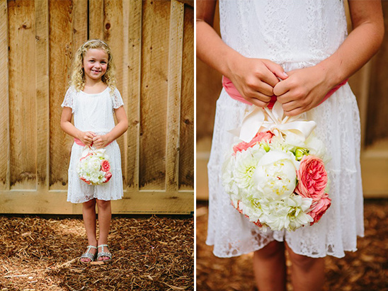 Young girl in white dress with a floral bouquet at a wedding