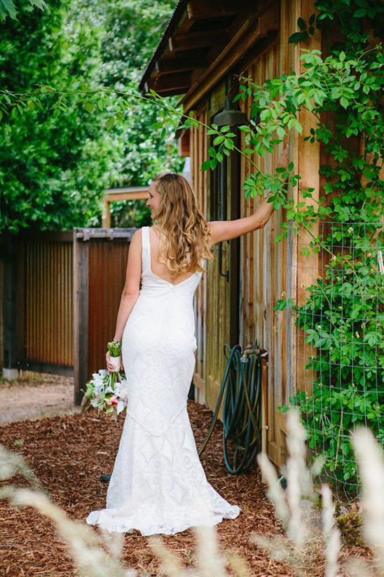 Bride in a white wedding dress by a rustic wooden building