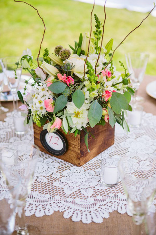 Elegant floral centerpiece on a rustic table at an outdoor event