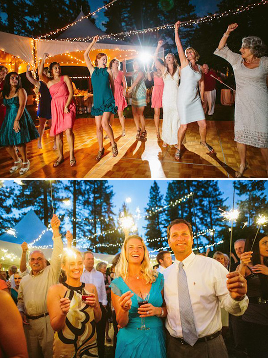 Wedding guests joyfully dancing with sparklers at night