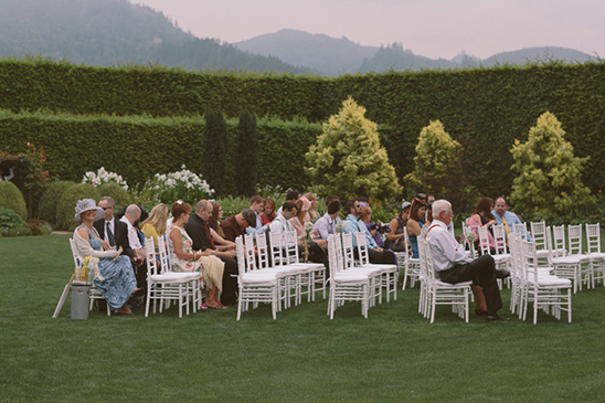 Guests gathered for an outdoor wedding ceremony in a beautiful garden