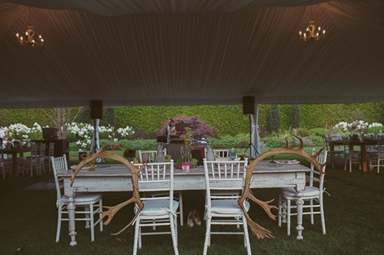 Rustic outdoor wedding reception with deer antlers decor