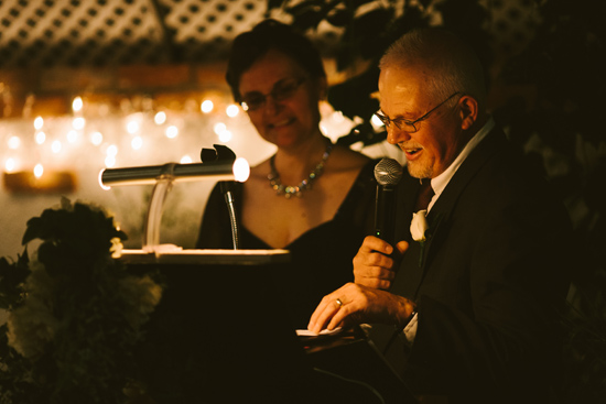 Man giving a speech at a celebration with a woman by his side
