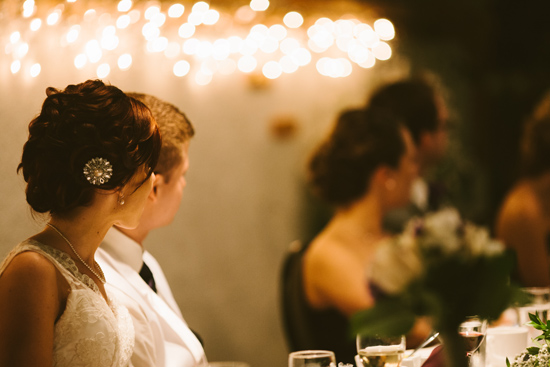 Wedding guests at a candlelit reception looking onward