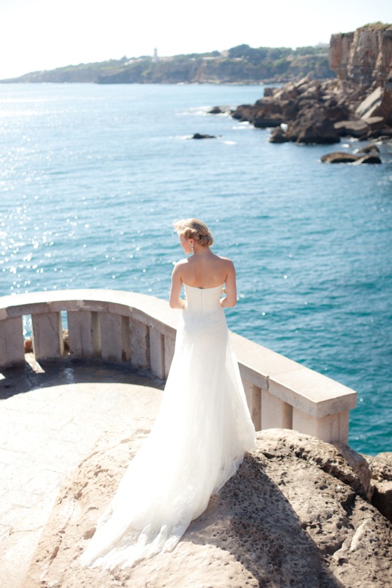 Bride in a white dress overlooking the ocean on her wedding day