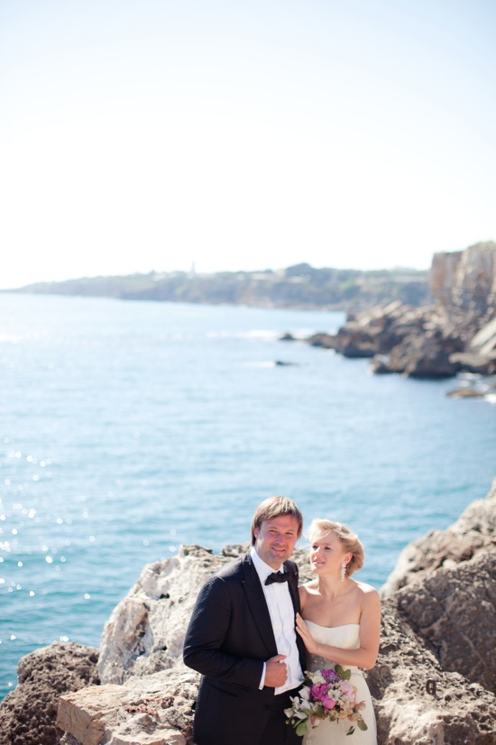 Happy wedding couple posing by the beautiful ocean scenery