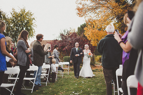 Bride walking down the aisle with her father at outdoor fall wedding