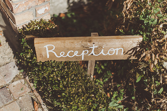 Rustic wooden reception sign guiding guests to the celebration