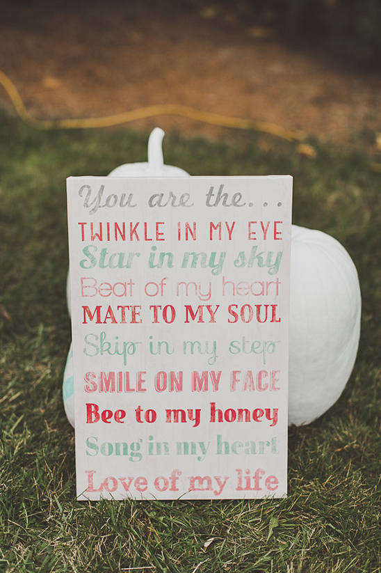 Sign with loving phrases, placed in front of a white pumpkin