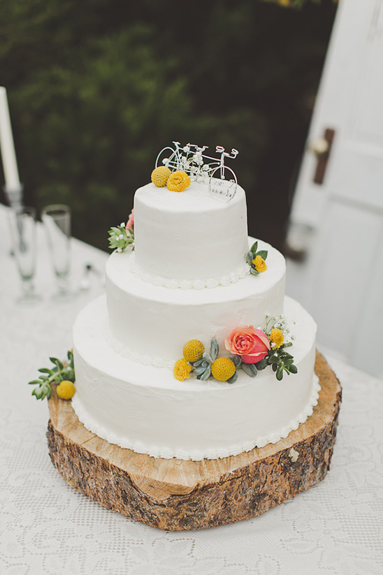 Rustic three-tier wedding cake with tandem bike topper