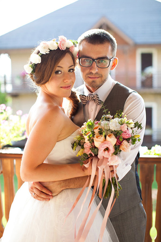 Happy bride and groom embracing with bouquet