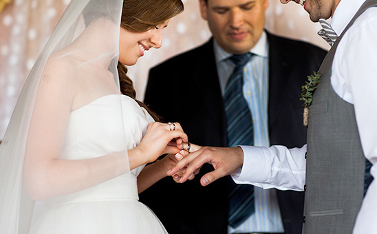Bride and groom exchanging wedding rings