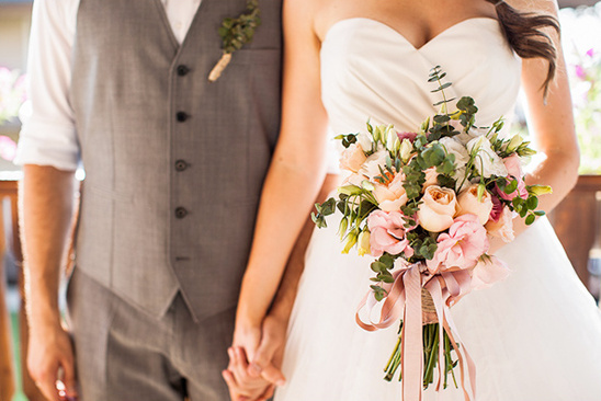 Happy couple holding wedding bouquet