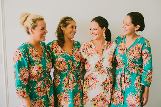 Bridesmaids in floral robes, smiling and ready for the big day