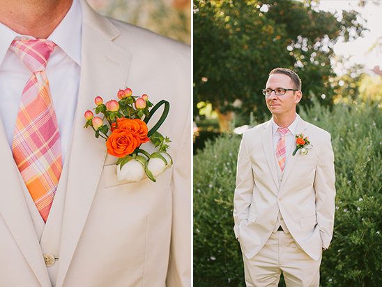 Groom in beige suit with a colorful plaid tie and floral boutonniere