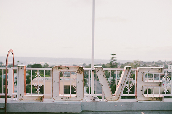 Large LOVE sign on a rooftop with scenic city view