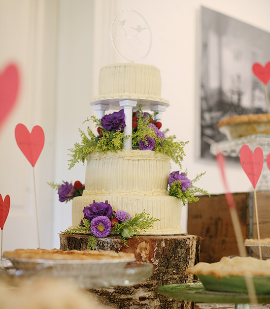 Beautiful three-tiered wedding cake decorated with purple flowers