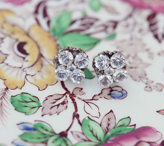 Sparkling diamond earrings resting on a floral patterned surface