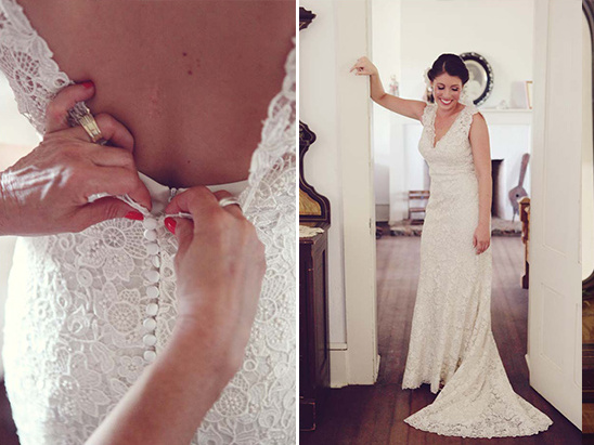 Bride getting ready for her wedding, buttoning up her lace dress