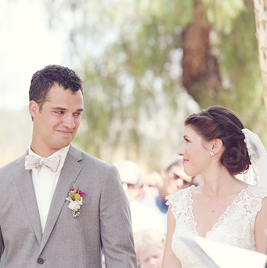 Groom looks at bride with love during outdoor wedding ceremony