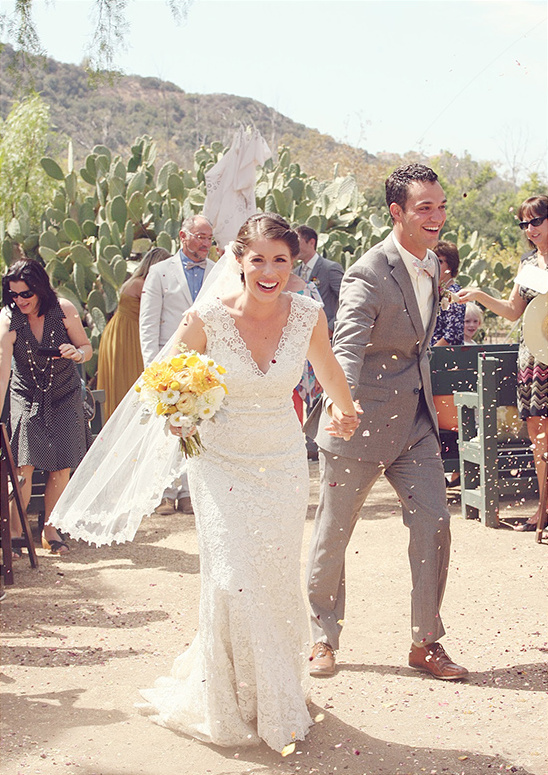 Joyful bride and groom walking down the aisle after the wedding