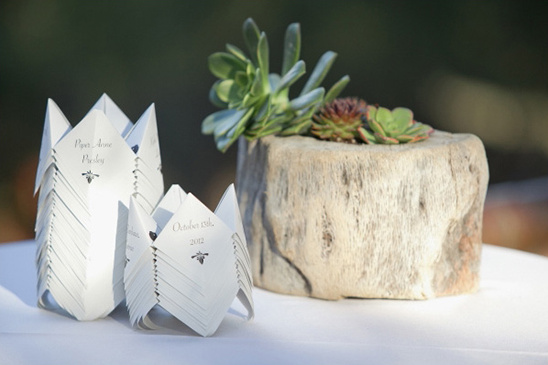Wedding place cards folded as origami boats with succulents